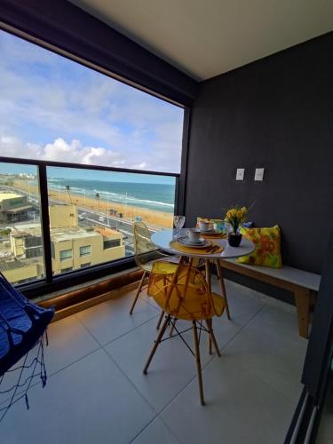 a dining room with a table and a view of the beach at VAN GOGH-SE Studio privado com Rooftop, garagem, piscina aquecida in Salvador