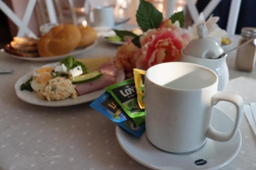a table with plates of food and a cup of coffee at Hotel Grand Felix in Kraków