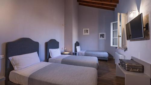 a hotel room with two beds and a flat screen tv at Hotel Cortaccia Sanvitale in Sala Baganza