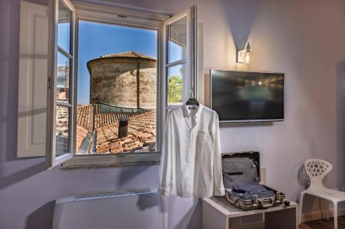a robe hanging on a window in a room at Hotel Cortaccia Sanvitale in Sala Baganza