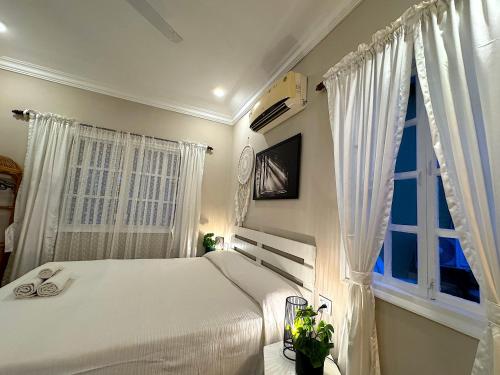a bedroom with a white bed and a window at Nestwood - By The Beach Goa in Benaulim
