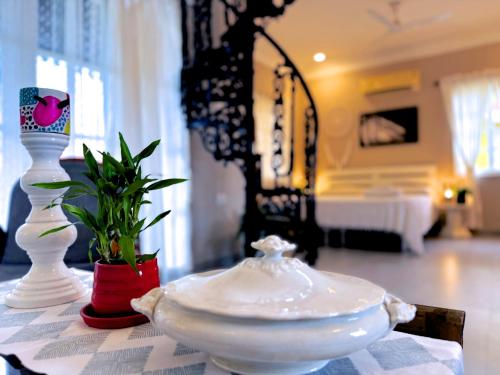 a table with two white vases on top of a table at Nestwood - By The Beach Goa in Benaulim
