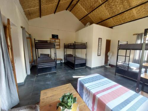 a room with three bunk beds and a table at Himkosi Farm by the River in Almora