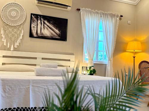 a bedroom with a white bed and a window at Nestwood - By The Beach Goa in Benaulim