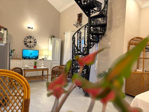 a living room with a table and a clock on the wall at Nestwood - By The Beach Goa in Benaulim