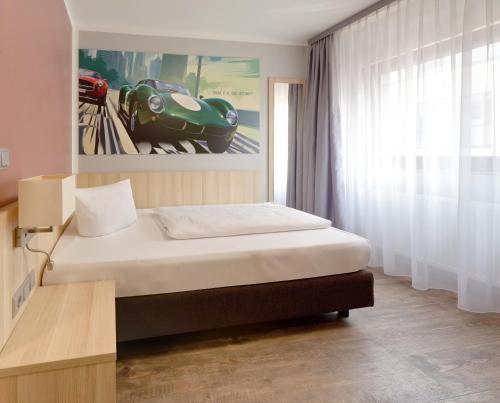 a bedroom with a bed and a picture of a car at attimo Hotel Stuttgart***S in Stuttgart