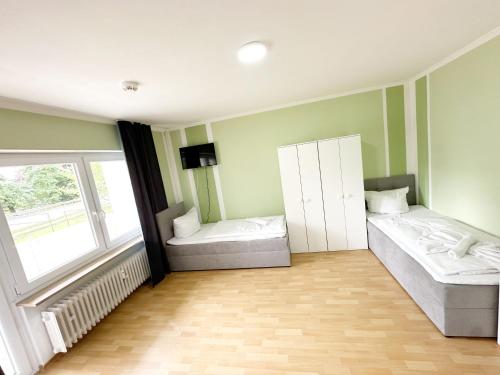a room with two beds and a tv in it at SUNNYHOME Monteurwohnungen und Apartments in Weiden in Weiden