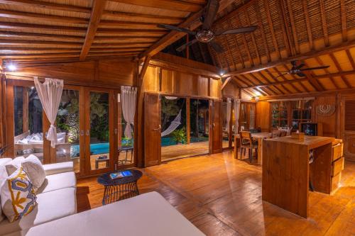 a living room with wooden walls and a ceiling at Wanderlust Villa by Betterplace in Dalung