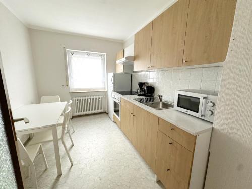 a small kitchen with a table and a microwave at SUNNYHOME Monteurwohnungen und Apartments in Weiden in Weiden