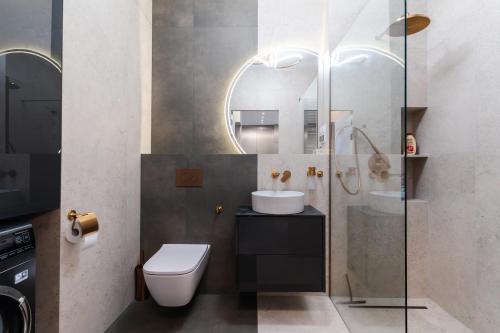 a bathroom with a toilet and a sink and a mirror at Panoramica House 17 piętro in Poznań