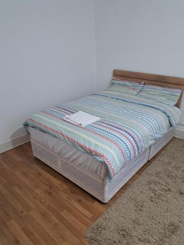 a bed sitting in a bedroom with a rug at London Ilford town house in Ilford