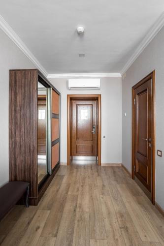 an empty hallway with wooden floors and doors at Sacvoyage Hotel in Almaty