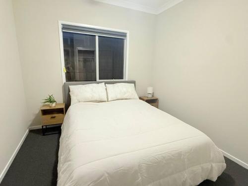 a white bed in a room with a window at Silky Oak Stay - Brand New House in Griffin in Griffin