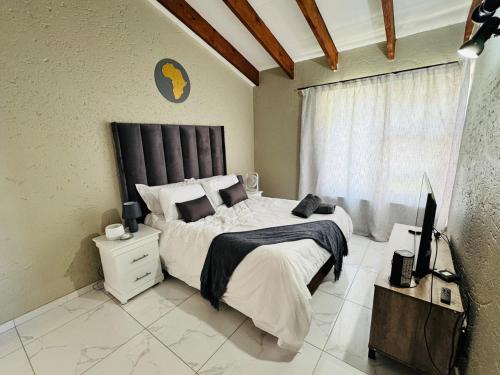 a bedroom with a large bed and a window at Villa Picasso - 2 Bed Villa in Johannesburg
