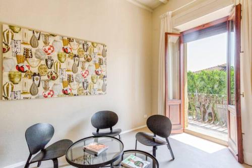 a room with chairs and a table and a window at San Prospero Heritage in Siena