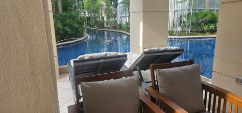 a balcony with chairs and a view of a swimming pool at Hua Hin Blue Lagoon in Cha Am