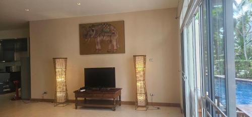 a living room with a flat screen tv and an elephant on the wall at Hua Hin Blue Lagoon in Cha Am