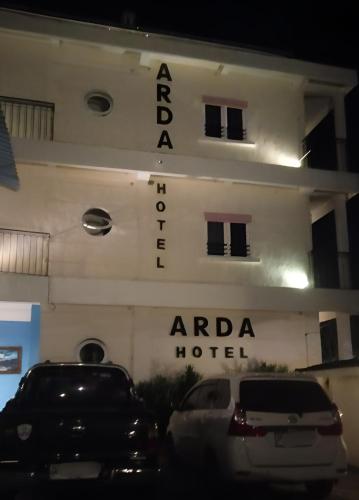 a hotel with cars parked in front of it at Hotel Arda Bali in Negara