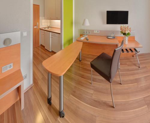 a dining table and a chair in a room at attimo Hotel Stuttgart***S in Stuttgart