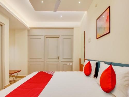 a bedroom with a large bed with red pillows at Collection O Peak Stay in Porvorim