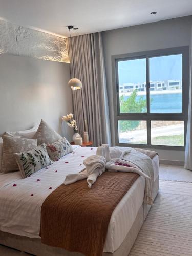 a bedroom with a large bed with a large window at Amwaj Resort For Families Only in Al Khobar