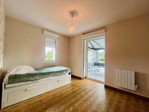 a bedroom with a bed and a large window at Le Logis des Pres Country Stay 