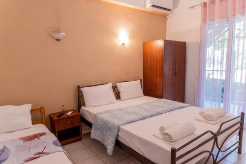 a bedroom with two beds and a window at Apartment's Eleni in Kamena Vourla