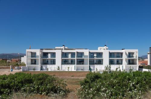 a large white building with bushes in front of it at Oliva Suites in Oliva