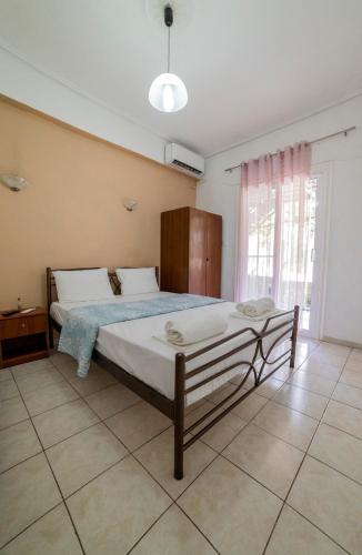 a bedroom with a bed and a large window at Apartment's Eleni in Kamena Vourla