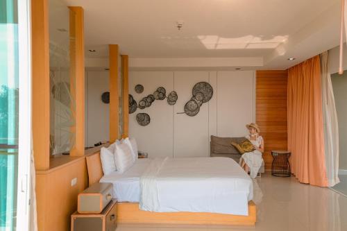 une femme assise sur un canapé dans une chambre dans l'établissement Welcome World Beachfront Resort, à Pattaya (sud)