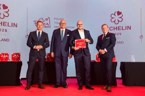 a group of four men standing on a red carpet accepting an award at City Park Hotel & Residence in Poznań