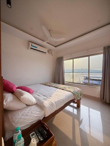a bedroom with a bed with a view of the ocean at Nadhi Mane River-front Beach Stay in Tadri