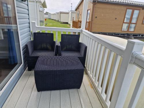 a balcony with two chairs and a railing at Acer Leaf - 2 bedrooms sleeps 6 in Camber