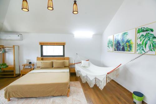 ハイフォンにあるMango Riverside Hotel & Apartment - Hai Phongのベッド2台とブランコのある寝室