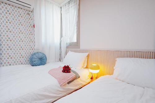 two beds in a bedroom with a flower arrangement on top at 레토하우스 