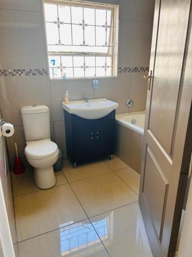 a bathroom with a sink and a toilet and a window at Bisho Grand Escape in Bisho