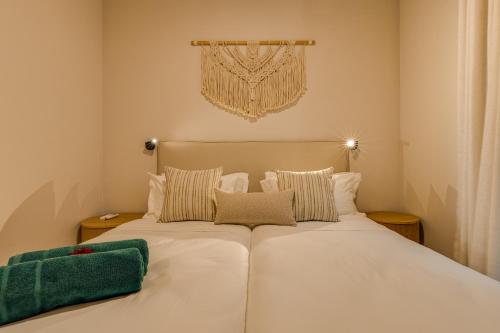 a bedroom with a bed with white sheets and pillows at Le Dalblair by Horizon Holidays in Pointe d'Esny