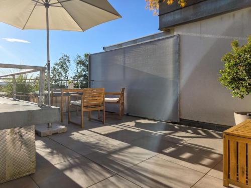 a patio with an umbrella and a table and chairs at Säntisblick Apartment in Schwarzach