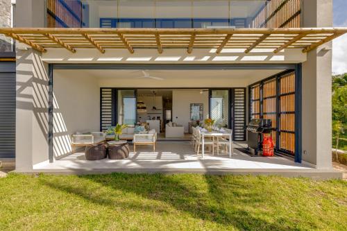 an outdoor patio with a wooden pergola at Le Dalblair by Horizon Holidays in Pointe d'Esny