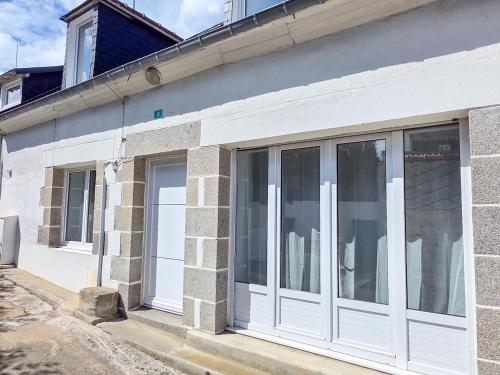 a white building with sliding glass doors on it at La Flibuste, Vue Mer, Plage à Pied & Parking in Plérin