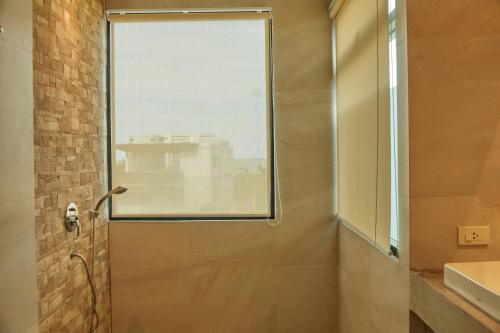 a bathroom with a shower with a window and a sink at Whale Hua Hin - SHA Plus in Hua Hin