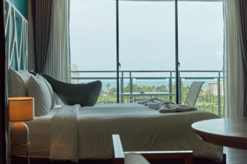 a bedroom with a bed and a large window at Whale Hua Hin - SHA Plus in Hua Hin