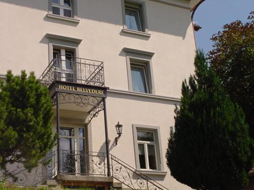 a building with a balcony and a sign on it at Hotel Restaurant Belvedere in Weissbad