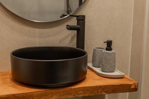 a black bowl on a wooden counter with a sink at The Uppertown Nest - By Urban Minds in Thessaloniki