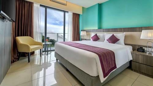 a bedroom with a large bed and a yellow chair at Highland Breeze Hotel in Genting Highlands