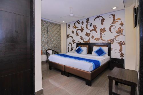 a bedroom with a bed with blue pillows at Hotel O The Moon in New Delhi