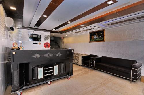 a living room with a fireplace and a black couch at Hotel O The Moon in New Delhi