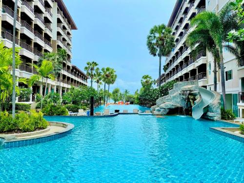 a swimming pool in a resort with a water slide at Welcome World Beachfront Resort in Pattaya South