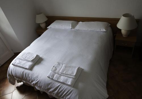 a white bed with two towels on top of it at Hotel Portici in Vicoforte