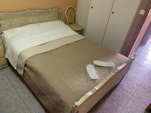 a bed with a pair of shoes sitting on it at Despoina Apartments in Edipsos